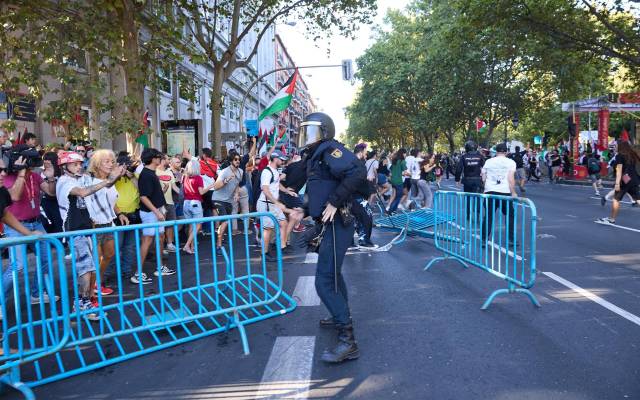 Un agente de Policía Nacional entre vallas tiradas tras cargas policiales a manifestantes que han protestado a favor de Palestina, el día de la etapa 21 de la Vuelta Ciclista a España, a 14 de septiembre de 2025, en Madrid