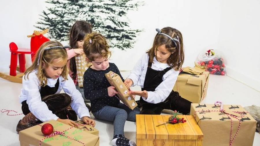 Foto de archivo de varias niñas con regalos de navidad