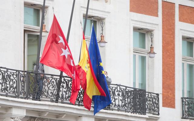 Banderas a media asta en la Real Casa de Correos, sede de la Comunidad de Madrid