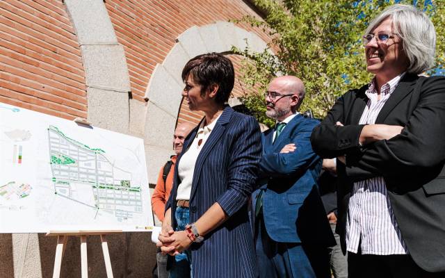 La ministra de Vivienda y Agenda Urbana, Isabel Rodríguez, observa los planos durante su visita a las viviendas de los terrenos de Campamento