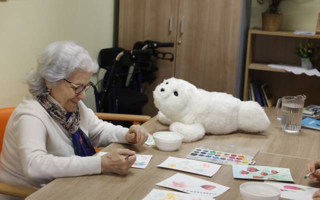 Usuaria del Centro de Día Municipal María Teresa León, en Chamberí, con el robot terapéutico Nuka