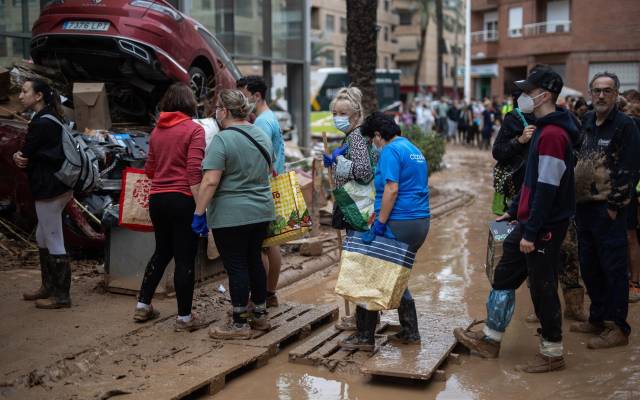 Varias personas hacen cola para conseguir comida en una de las zonas más dañadas por la DANA