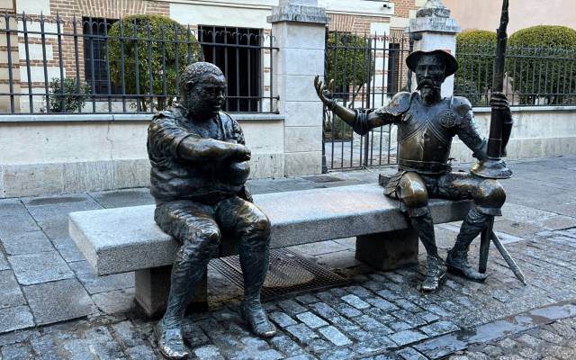 Estatuas de bronce de Don Quijote y Sancho Panza sentados en un banco del municipio