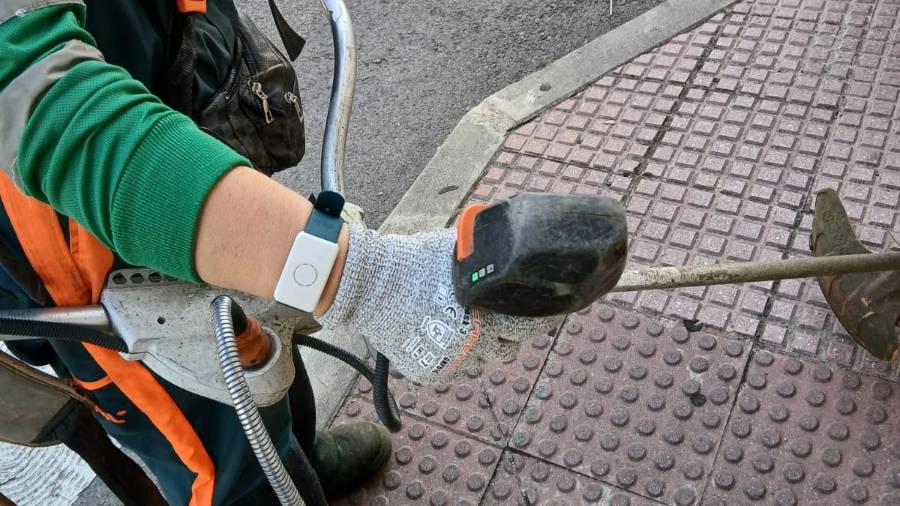 Una persona del servicio de limpieza de Alcalá de Henares con la pulsera inteligente incorporada al servicio para monitorizar la temperatura corporal con el objetivo de prevenir golpes de calor