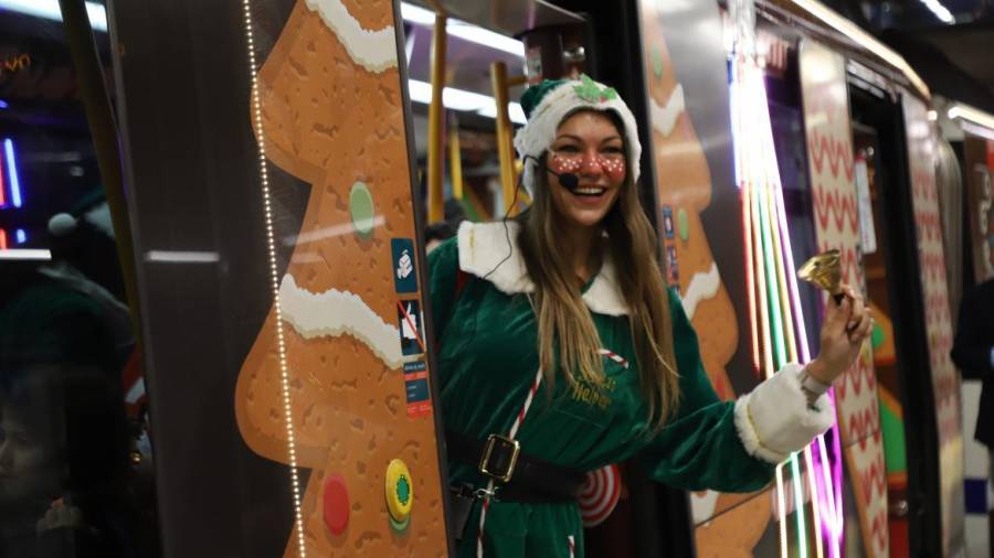 Los elfos del tren de la Navidad avisan con una campana a los viajeros del andén