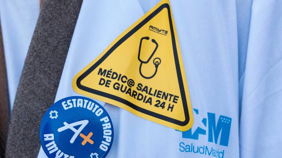 Un médico lleva una pegatina reivindicativa durante una concentración