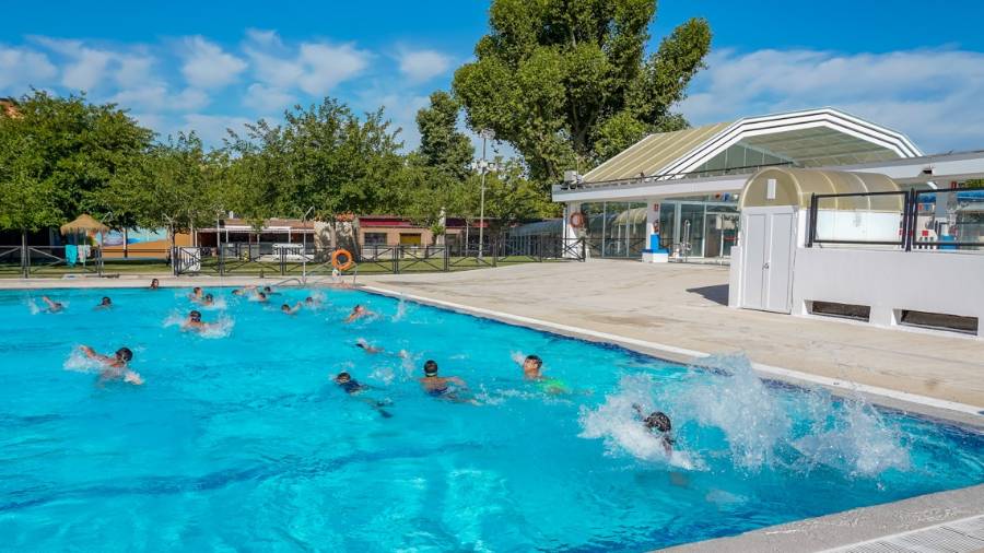 Escolares practicando natación en una piscina municipal