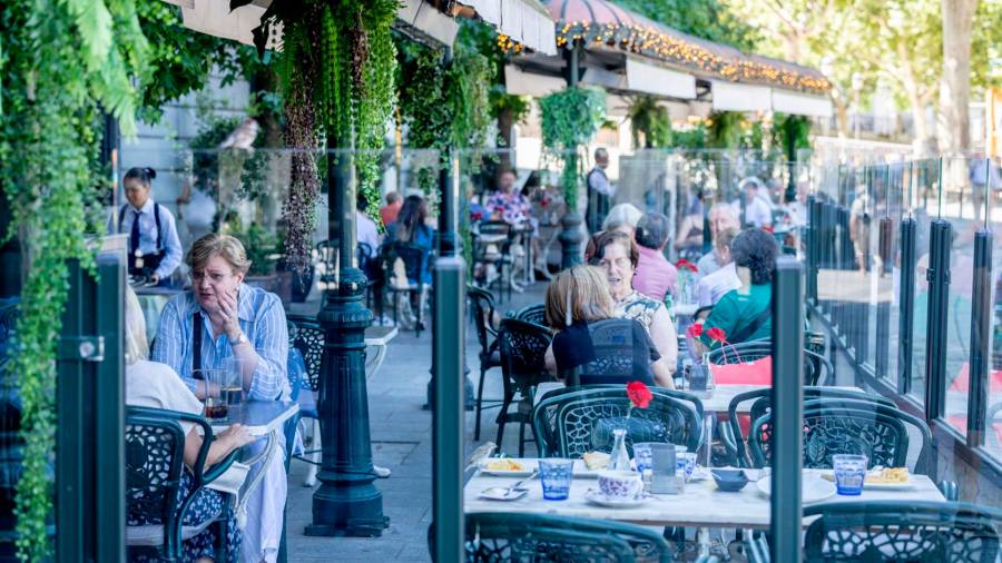 Clientes de un bar se refrescan en la terraza