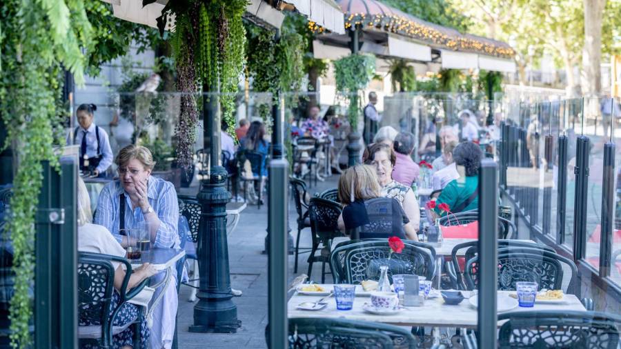 Clientes de un bar toman algo en la terraza