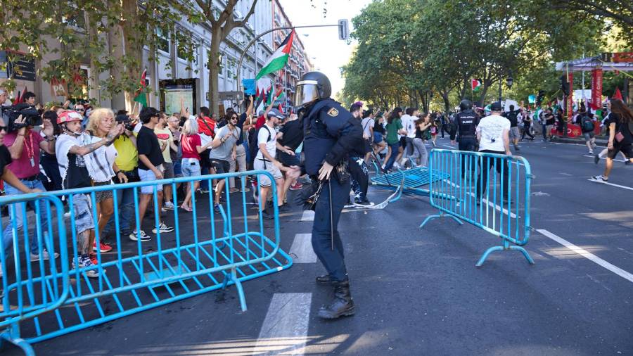 Un agente de Policía Nacional entre vallas tiradas tras cargas policiales a manifestantes que han protestado a favor de Palestina, el día de la etapa 21 de la Vuelta Ciclista a España, a 14 de septiembre de 2025, en Madrid