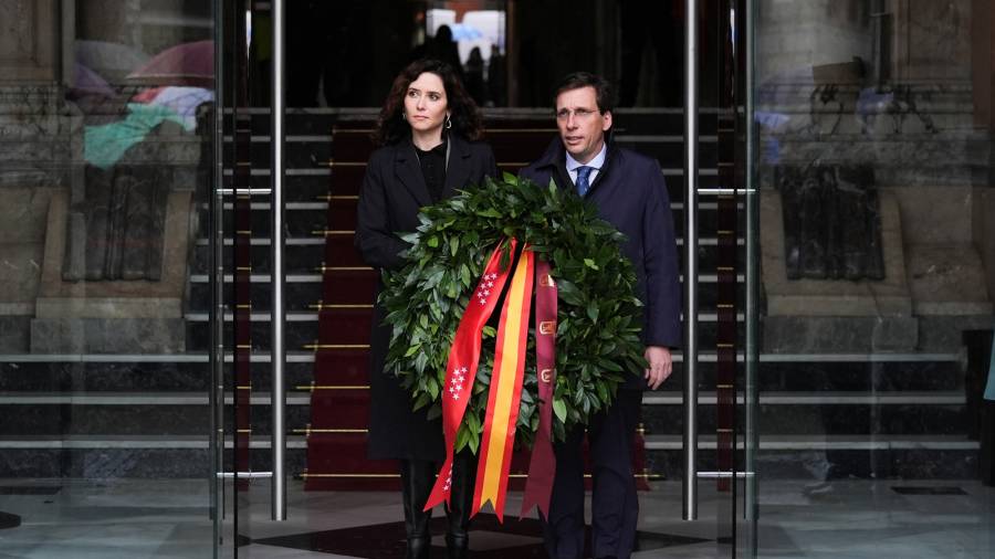 La presidenta de la Comunidad de Madrid, Isabel Díaz Ayuso, y el alcalde de la capital, José Luis Martínez-Almeida, depositan una corona de laurel en la placa en su memoria en la fachada de la Real Casa de Correos