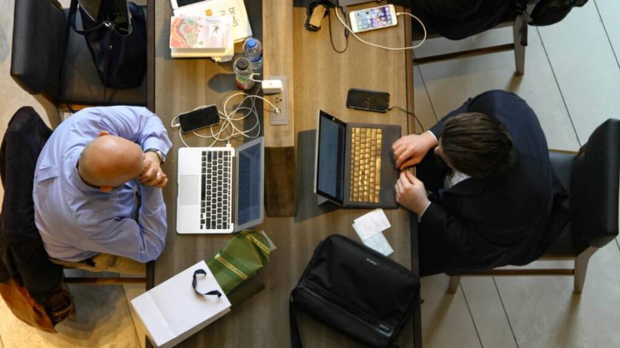Plano cenital de varias personas trabajando con sus ordenadores portátiles