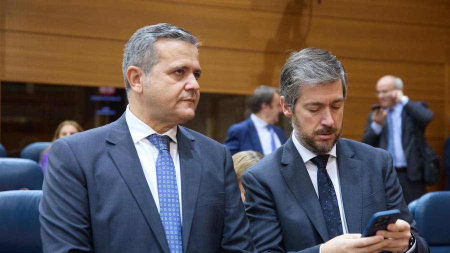 El consejero de Vivienda, Transportes e infraestructuras, Jorge Rodrigo (i), y el consejero de Presidencia, Justicia y Administración Local, Miguel Ángel García (d), durante un pleno en la Asamblea de Madrid