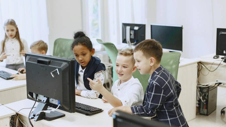 Varios menores en un aula escolar con ordenadores