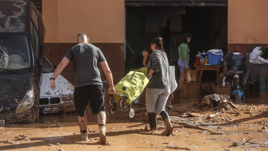 Varias personas limpian los destrozos tras el paso de la DANA