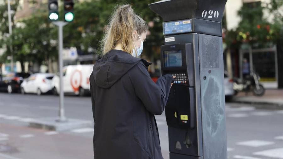 Una joven utiliza un parquímetro del Servicio de Estacionamiento Regulado (SER) de Madrid