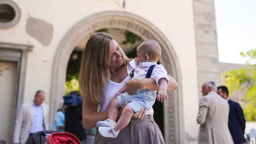 La consejera de Familia, Juventud y Asuntos Sociales, Ana Dávila, sostiene en brazos a un bebé en acogida en la residencia infantil El Encinar de Madrid